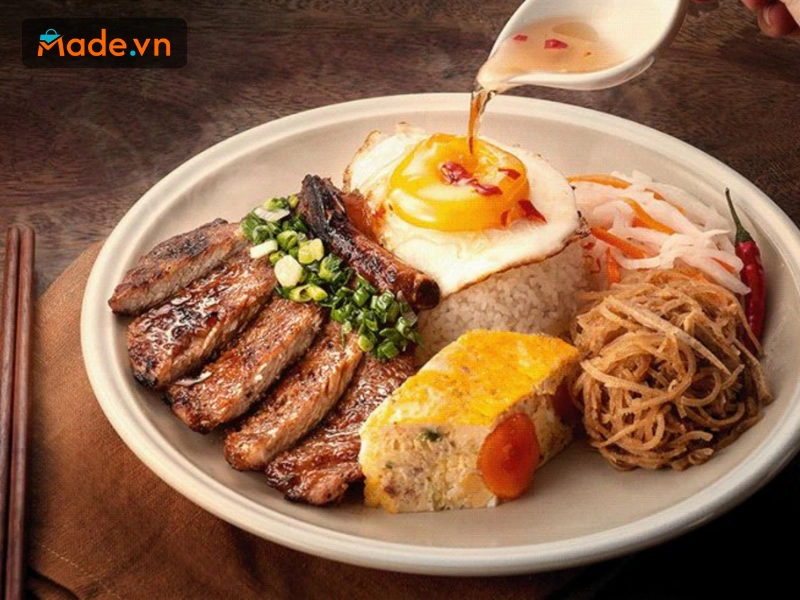 Đĩa cơm tấm nổi tiếng với sườn nướng mỡ hành thơm phức, bì heo dai giòn, chả trứng béo ngậy