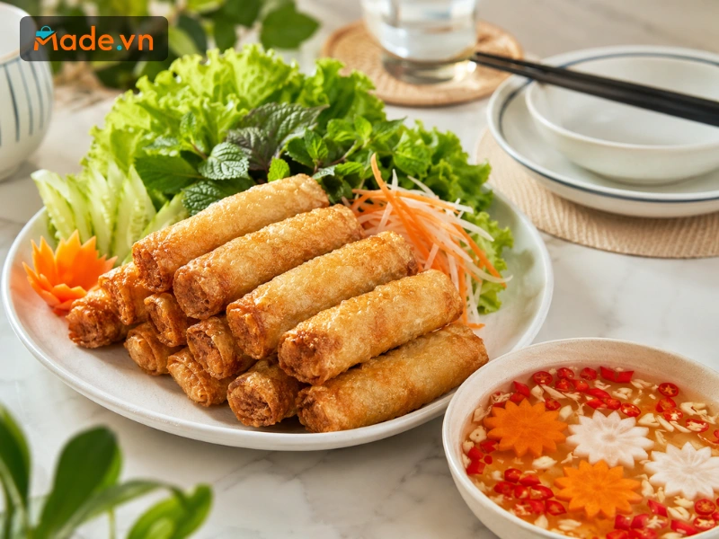 Đĩa nem rán với vỏ ngoài ráo dầu giòn rụm cùng bát nước chấm tỏi ớt chua ngọt